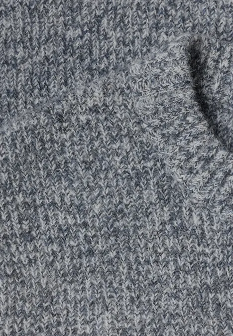 Nahaufnahme eines graublauen Strickpullovers mit sichtbarer Tasche.