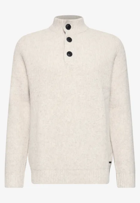 Modischer cremeweißer Strickpullover mit hohem Kragen und drei schwarzen Knöpfen.
