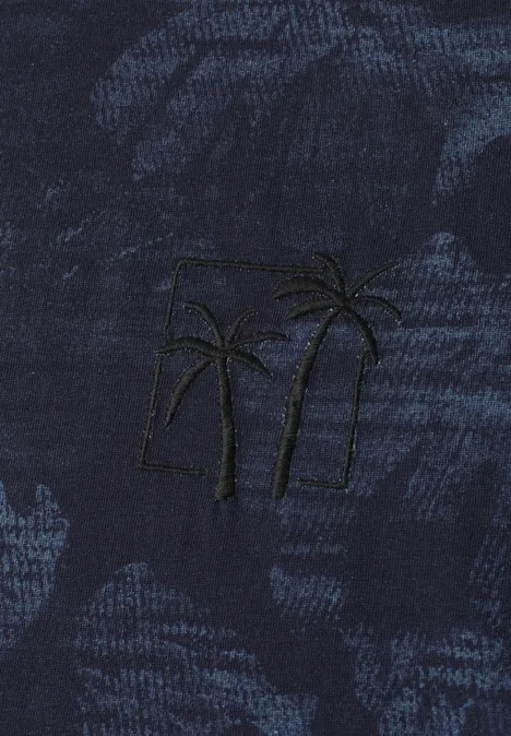 Donkerblauw stof met geborduurd motief: twee palmbomen voor een rechthoek.