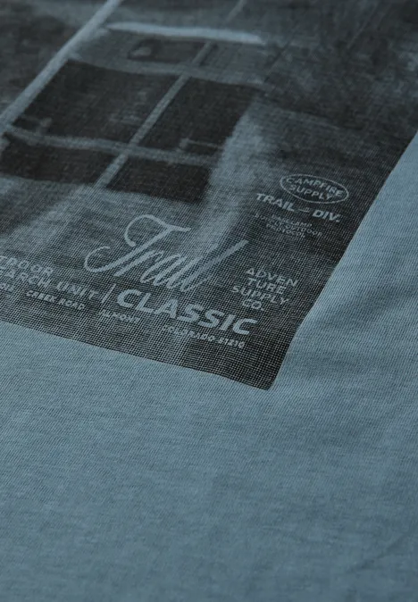 Hellblaues T-Shirt mit rechteckigem, dunklem Foto-Print und Text 'Tull Classic' auf der Vorderseite.