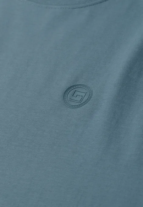 Blauwgrijs T-shirt met een rond, ton-sur-ton logo op de borst