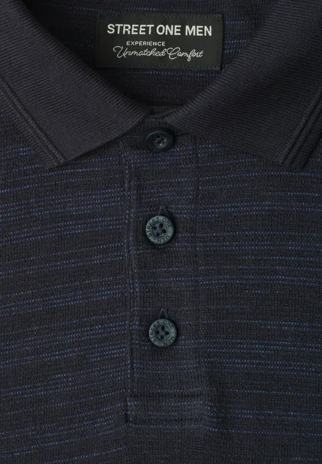 Nahaufnahme eines dunkelblauen Poloshirts mit feinen hellblauen Streifen, drei Knöpfen und Street One Men-Label.