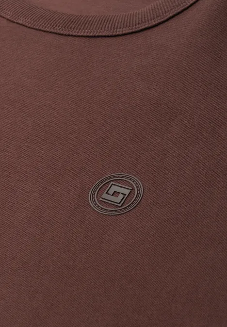 Braunes T-Shirt mit kleinem rundem Logo in der Mitte.