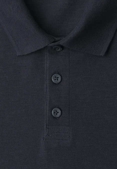 Nahaufnahme eines dunkelblauen Poloshirts mit Kragen und drei Knöpfen auf der Vorderseite.