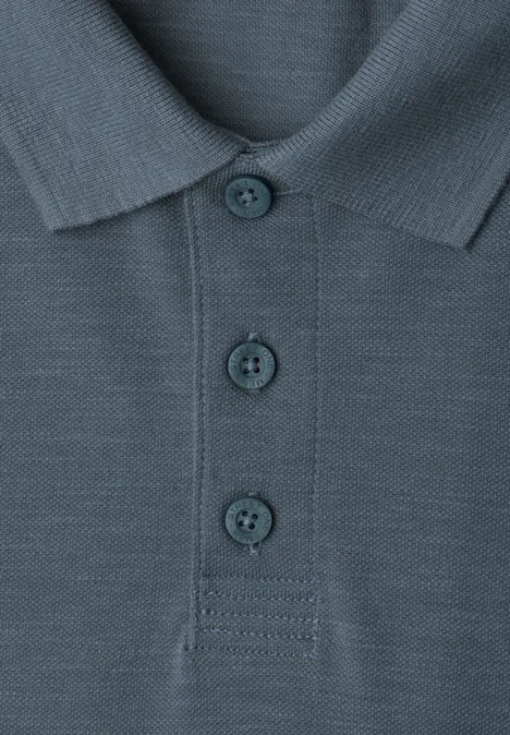 Nahaufnahme eines blaugrauen Poloshirts mit drei Knöpfen und Kragen.