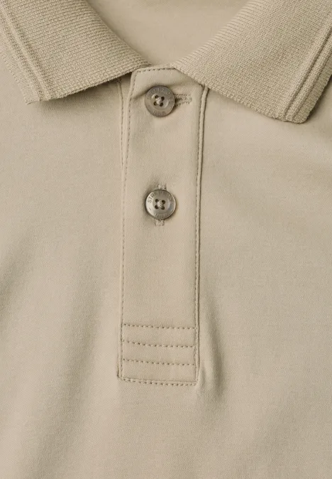 Nahaufnahme eines beigen Poloshirts mit Kragen und zwei Knöpfen.