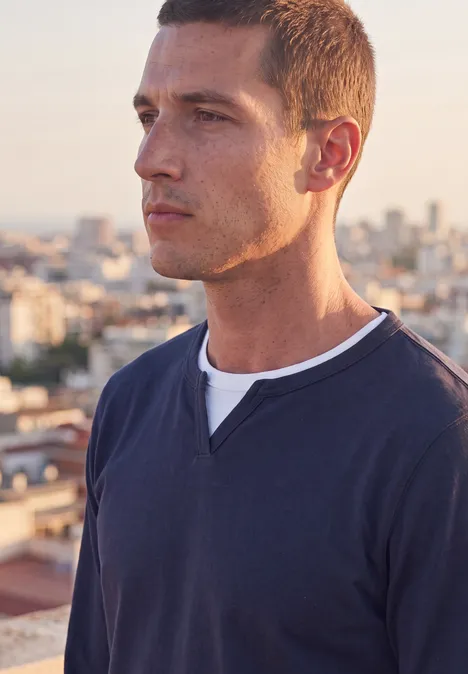 Henleyshirt im 2-in-1-Look dark ink blue Ein Mann steht auf einem Dach, trägt einen dunkelblauen Pullover und blickt über die Stadt im Sonnenlicht.