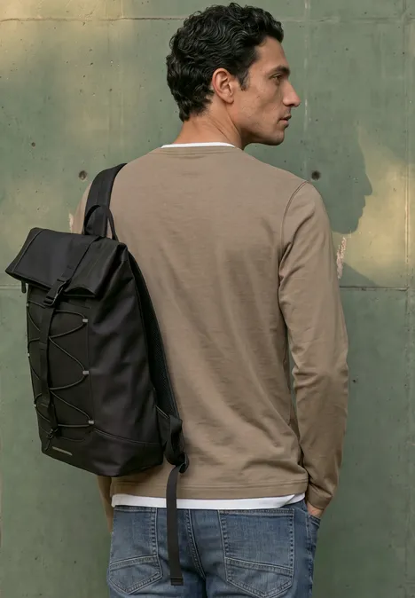 Henleyshirt im 2-in-1-Look antique beige Ein Mann mit schwarzem Rucksack, trägt ein langärmeliges Shirt und Jeans, steht seitlich vor einer grünen Wand