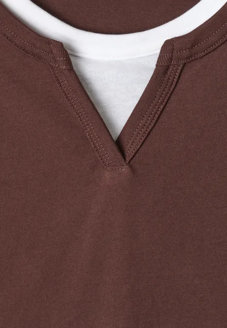 Nahaufnahme: Braunes V-Ausschnittshirt über weißem T-Shirt