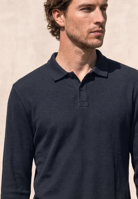 Langarm Poloshirt in Unifarbe dark ink blue Ein Mann mit braunen Haaren trägt ein dunkelblaues Langarm-Poloshirt vor hellem Hintergrund.