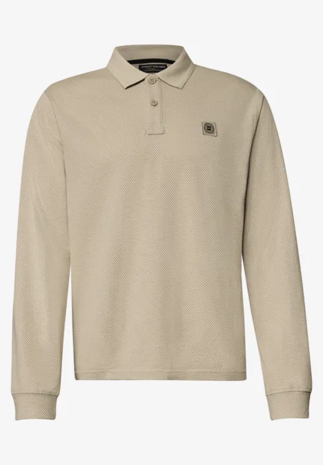 Polo à manches longues beige avec patte de boutonnage et petit logo discret sur la poitrine.