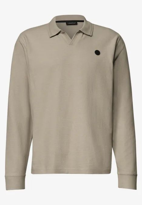 Polo beige à manches longues, col à revers en V et petit logo rond sur la poitrine.