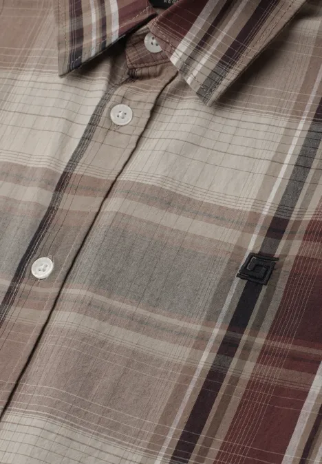 Nahaufnahme eines karierten Hemdes in Beige-, Braun- und Grautönen mit Knöpfen und kleinem Logo.