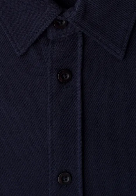 Nahaufnahme eines dunkelblauen Hemds mit Kragen und schwarzen Knöpfen.