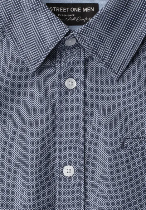 Hemd mit blauem Polka-Dot-Muster, weißen Knöpfen und spitzem Kragen.