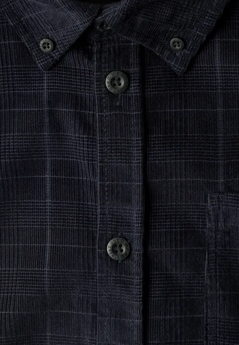Gros plan d’une chemise sombre à carreaux avec boutons et poche poitrine