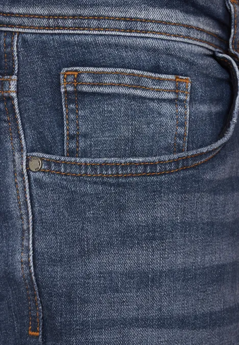Jean used coupe droite indigo blue wash Nahaufnahme einer Jeanstasche mit sichtbaren Nähten.