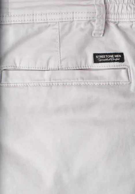 Nahaufnahme einer hellgrauen Stretch-Hose mit Gesäßtasche und Aufnäher am Bund