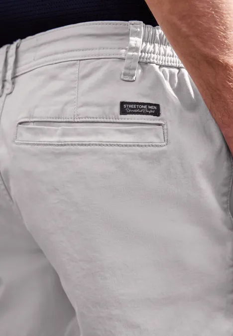 Nahaufnahme hellgrauer Freizeit-Shorts mit elastischem Bund und Label neben Gesäßtasche.