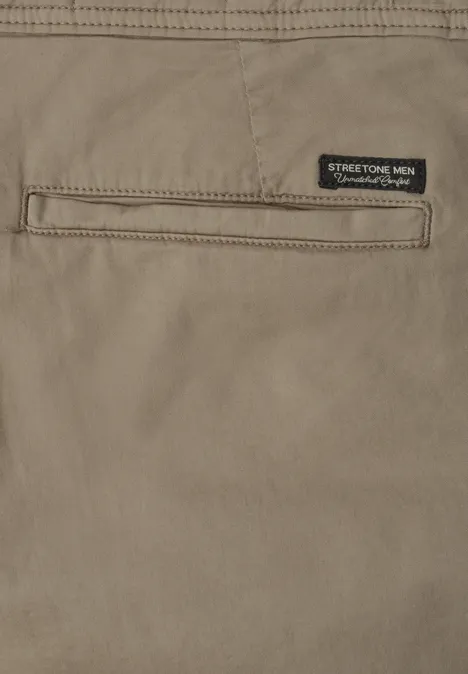 Nahaufnahme einer beigen Hose mit Gesäßtasche und kleinem Markenlabel