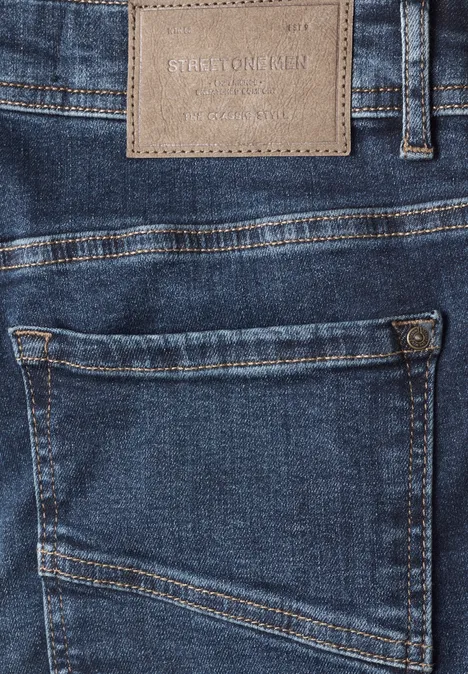 Gros plan d'un jean bleu avec poche arrière et écusson en cuir.