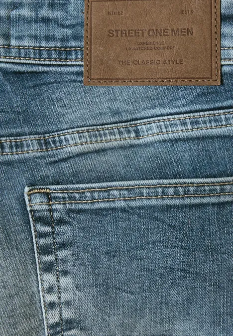 Nahaufnahme von blauer Jeans mit Tasche und braunem Lederpatch 'STREET ONE MEN' am Bund.