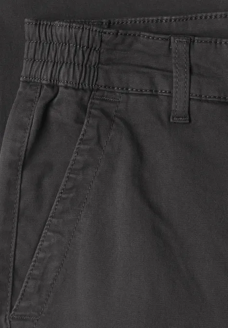 Nahe Ansicht einer schwarzen Hose mit Gummizug, Gürtelschlaufen und seitlicher Tasche.