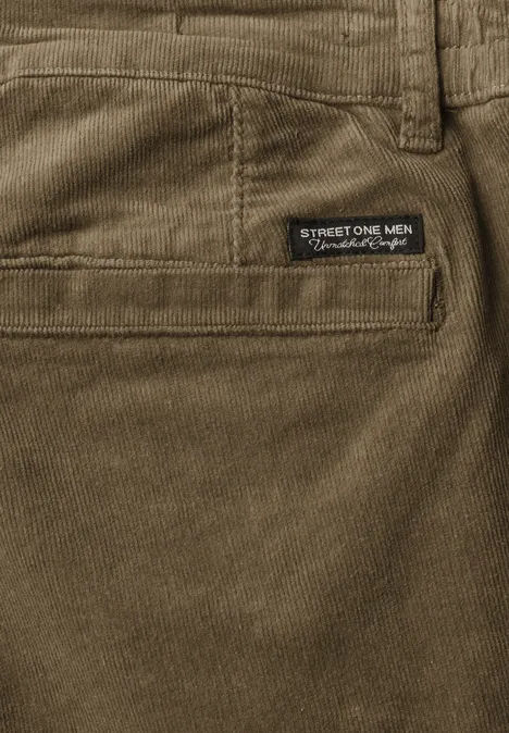 Nahaufnahme einer olivgrünen Cordhose mit Gesäßtasche und Markenlabel.