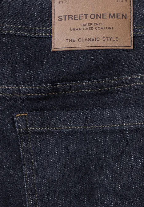 Gros plan d'un jean homme bleu foncé avec étiquette 'STREET ONE MEN - The Classic Style' et poche arrière