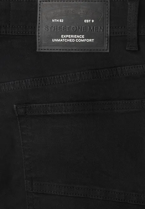 Dżinsy Slim Leg o kroju Slim Fit clean black Czarne dżinsy z czarną metką 'FOR MEN' i napisem 'EXPERIENCE UNMATCHED COMFORT'.