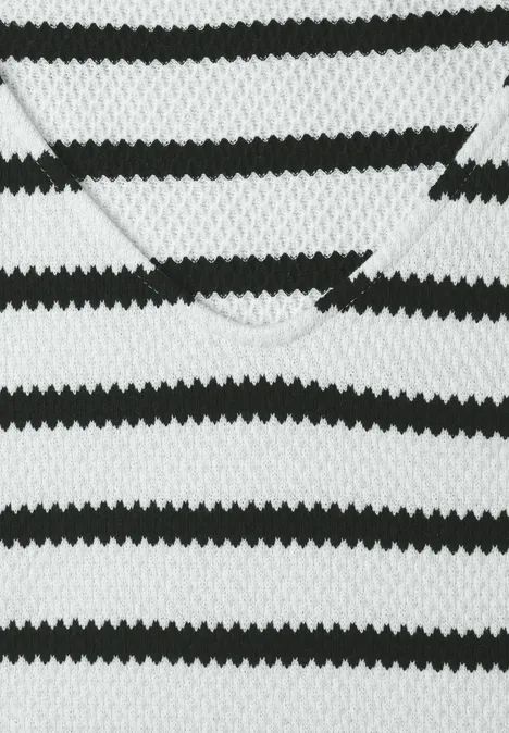 Nahaufnahme eines schwarz-weißen, gestreiften Strick-V-Ausschnitt-Pullovers.