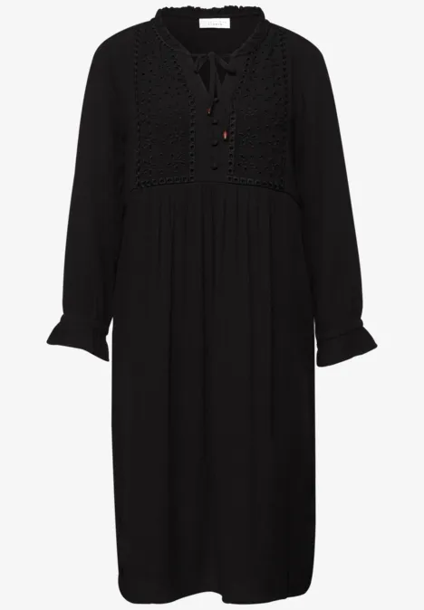 Zwarte midi-jurk met lange mouwen, kanten inzet in het bovenstuk en bindstrik bij de V-hals.
