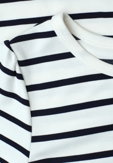 Close-up van een wit shirt met zwarte, horizontale strepen