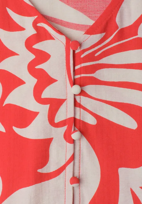 Rode blouse met gebroken-witte abstracte bloemenprint en stoffen knoopjes.