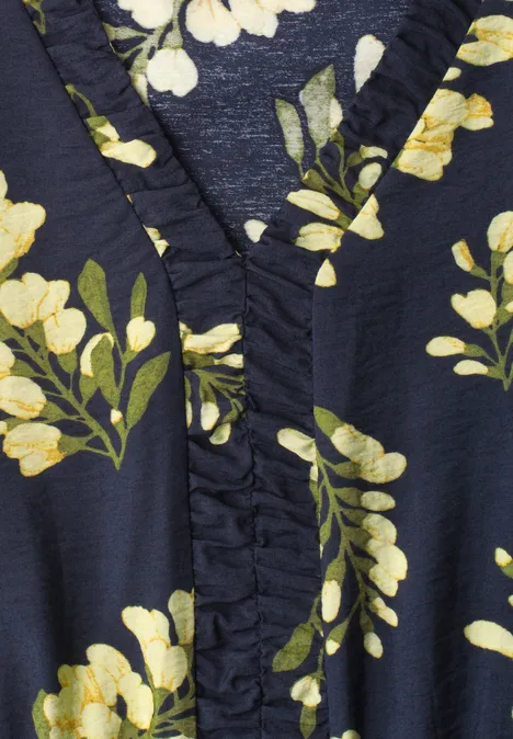 Detailaufnahme eines dunkelblauen Stoffs mit gelb-weißen Blumen und grünen Blättern