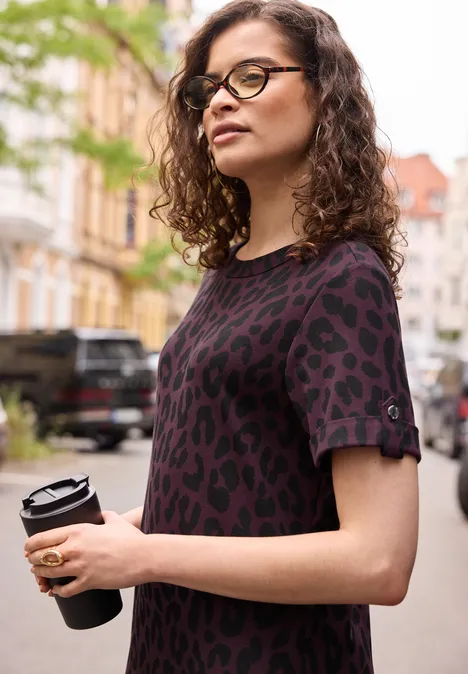 Midkleid mit Rundhals und Leo-Muster very berry Junge Frau mit lockigen Haaren hält einen Coffee-to-go-Becher, trägt lässiges Leoparden-Print-Shirt in der Stadt.