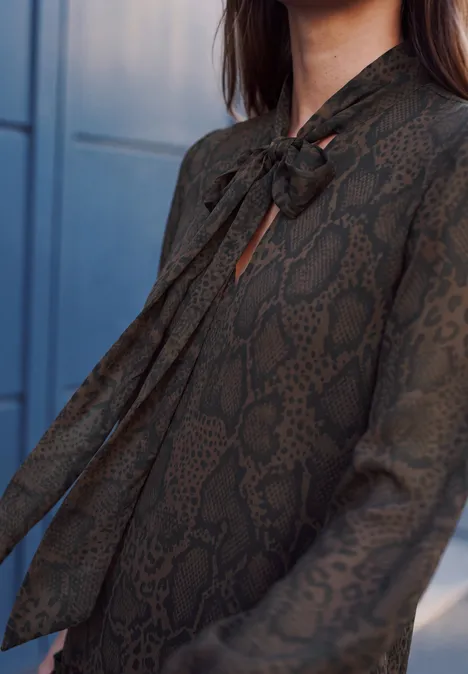 Knielanges Chiffonkleid mit Schalkragen charred brown Eine dunkelgrüne Damenbluse mit Schlangenmuster und elegantem Schleifenkragen.