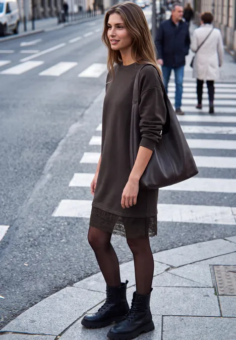 Minikleid mit Spitzendetail am Saum charred brown Eine junge Frau überquert lächelnd einen Zebrastreifen in der Stadt, trägt ein dunkelgrünes Kleid und Stiefel.