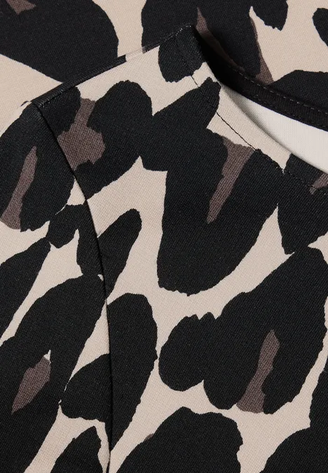 Robe mi-longue en jersey avec un nœud Black Motif abstrait sur tissu beige avec grandes taches noires irrégulières, évoquant un imprimé léopard.
