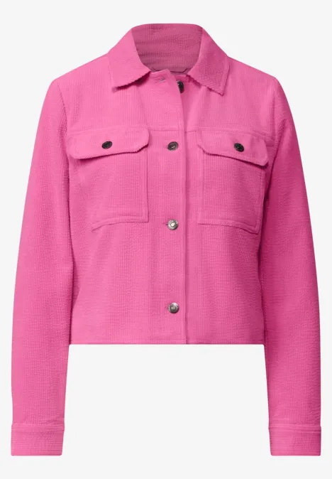Kurz geschnittene, pinke Jeansjacke mit Knopfleiste und Brusttaschen.