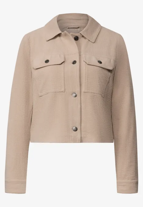 Beige kurze Jacke im Hemdfstil mit Brusttaschen und Metallknöpfen.