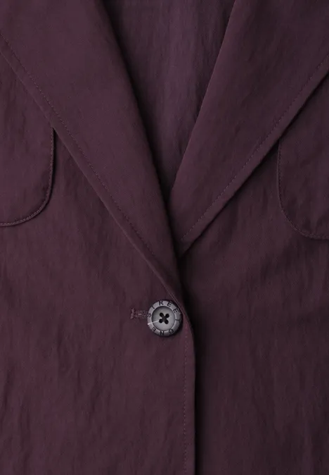 Nahaufnahme eines plumfarbenen Blazers mit Kragen und Knopf
