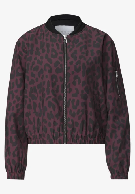 Een bordeaux bomberjack met zwart luipaardprint, ritssluiting vooraan en geribde kraag.