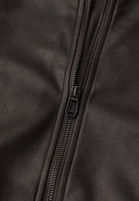 Blouson aspect cuir charred brown Nahaufnahme eines dunklen Lederstücks mit sichtbarem Reißverschluss.