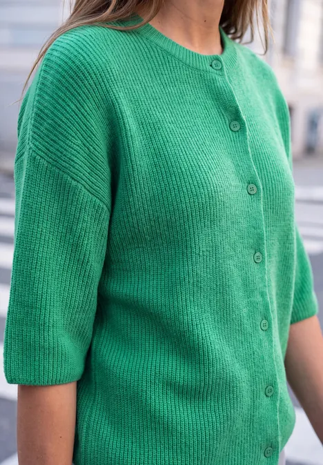 Grüne Strickjacke mit Knopfleiste und halblangen Ärmeln.