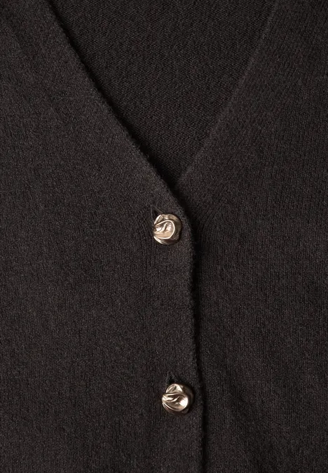 Schwarze Strickjacke mit V-Ausschnitt und zwei goldenen, gewellten Metallknöpfen.