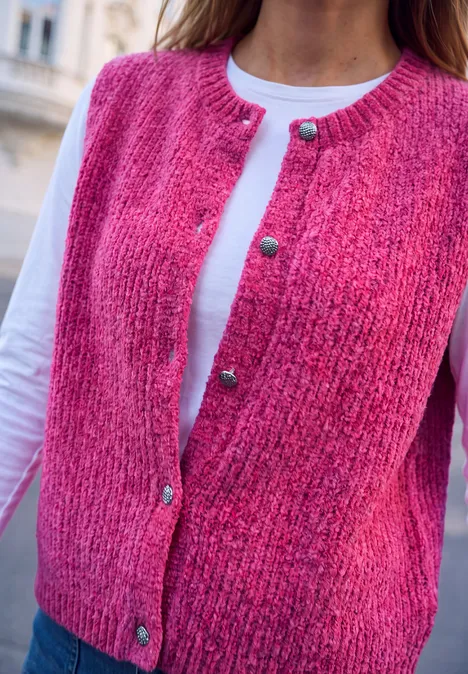 Strickweste mit Rundhals und Knöpfen ruby raspberry Rosa gestrickte Weste mit goldenen Knöpfen über weißem Shirt.