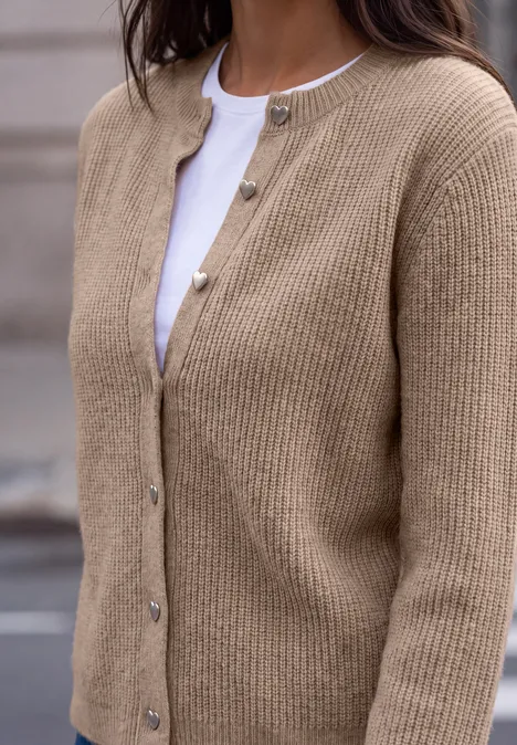 Cardigan à côtes et col rond biscuit sand mel. Person trägt eine beige Strickjacke mit Knöpfen über weißem Oberteil