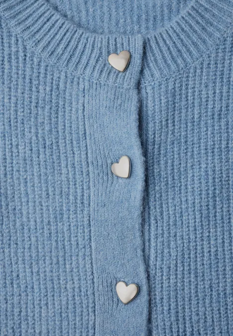 Cardigan à côtes et col rond loom blue mel. Hellblaue, gerippte Strickjacke mit drei weißen herzförmigen Knöpfen.