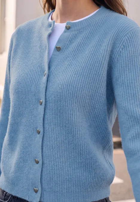 Cardigan à côtes et col rond loom blue mel. Hellblauer, gerippter Cardigan mit herzförmigen Knöpfen über weißem Shirt